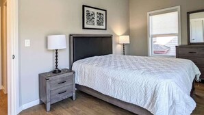 A bedroom with a bed, bedside tables, a dresser, and a window with blinds. - 223  Brand New 2 Bdrm, 2 BATH, 1 Liv, 1 Kith (Dunellen)