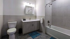 A modern bathroom with a toilet, sink, mirror, and shower. - 324 Brand New 1 Bedroom, 1 Bath, 1 Kitchen, 1 Liv (Dunellen)