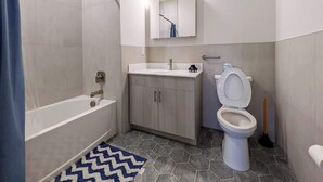 Un baño con bañera, inodoro y lavabo.
