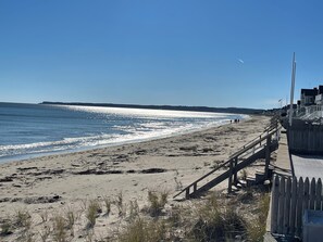 Une plage avec une promenade en bois et une vue dégagée sur l’océan.