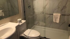 A bathroom with a toilet, sink, and shower area. - Houston Motor Inn (Houston)