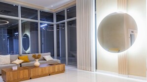 Una sala de estar moderna con sofá, mesa de centro y un espejo grande.