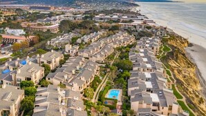 A coastal residential area with houses, a beach, and a distant cityscape. - BreathTaking View of Ocean Blue and Orange Sunsets (Solana Beach)