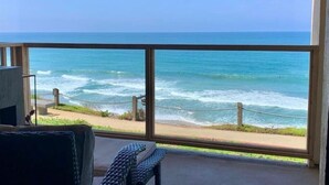 A balcony with a view of the ocean, a chair, and a small table. - BreathTaking View of Ocean Blue and Orange Sunsets (Solana Beach)