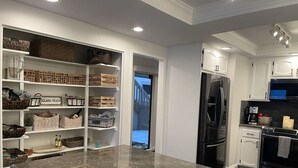 A modern kitchen with white cabinetry, a granite countertop, and built-in storage shelves. - BreathTaking View of Ocean Blue and Orange Sunsets (Solana Beach)