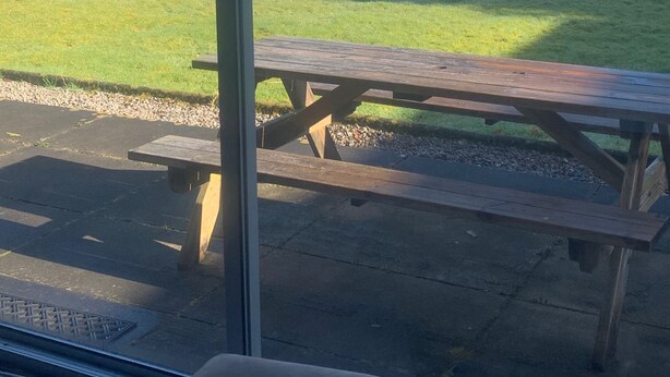 A view from a window overlooking a lake, picnic table, and grassy area. - Cozy Highland Retreat With Stunning Views (Invergarry)
