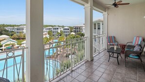 A balcony with a view of a swimming pool and surrounding buildings.
