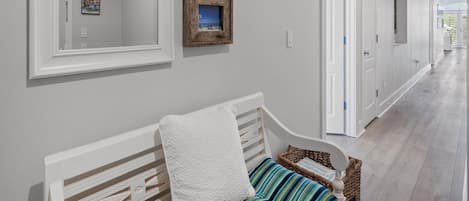 En gang med en bænk, indrammede billeder og et skilt med teksten 'BEACH'.