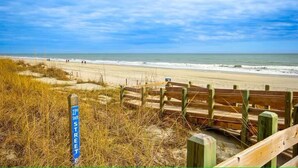 A beach with a wooden fence and a sign indicating '23rd South Street'. - North Myrtle Retreat, 2bd 2ba apartment in 3unit building 1-block from the Beach (North Myrtle Beach)