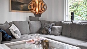 A modern living room with a grey sofa, a glass coffee table, and a decorative lamp. - 2 bedroom amazing home in Kalundborg (Kalundborg)