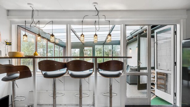 A modern kitchen with four bar stools, a wooden table, and pendant lights. - 2 bedroom amazing home in Kalundborg (Kalundborg)