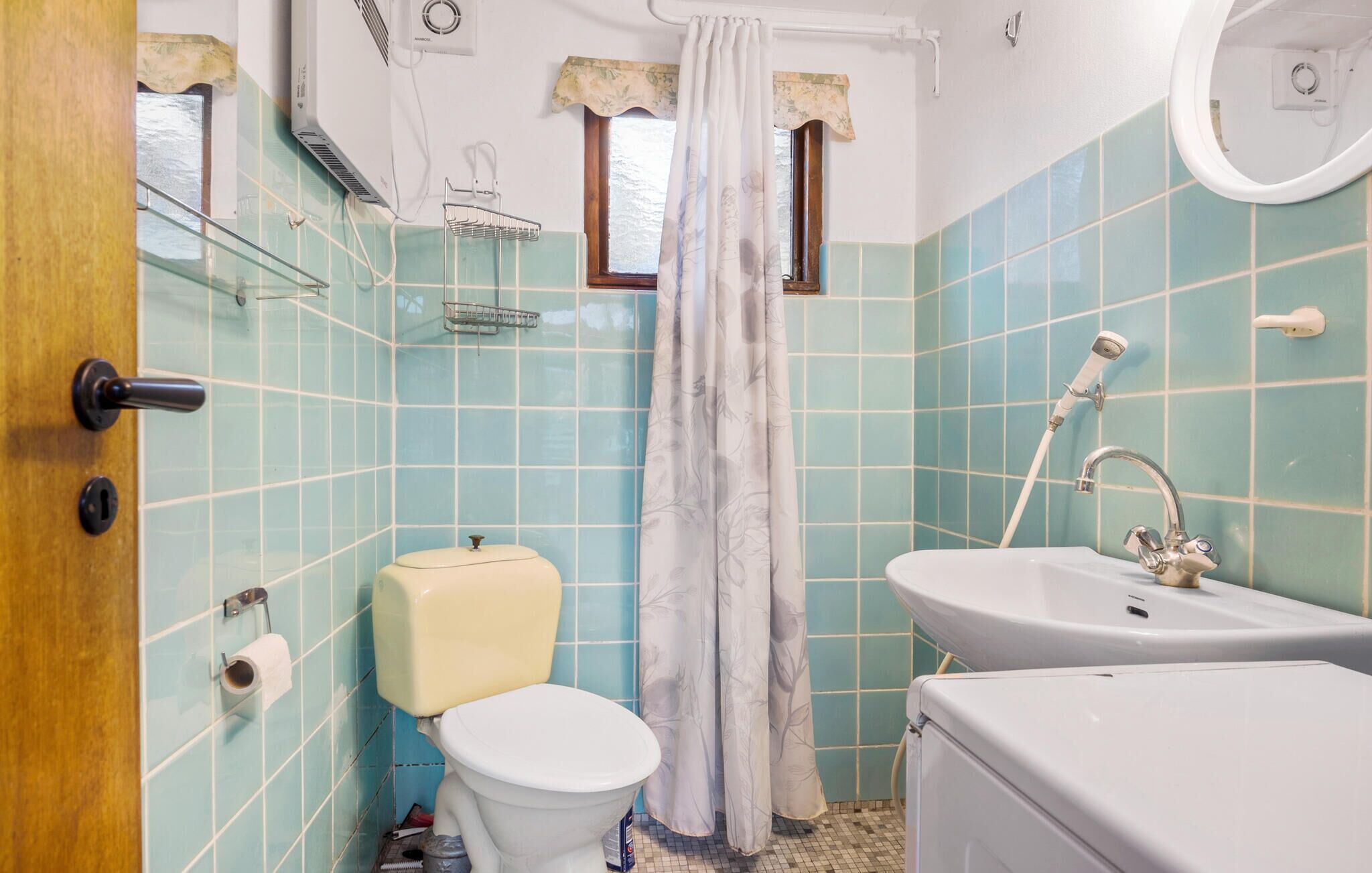 A bathroom with a toilet, sink, and shower.