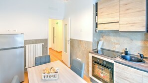 A modern kitchen with a built-in oven, a sink, and wooden cabinets. - Apartment in the heart of Civitavecchia (Civitavecchia)