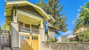 Una casa a due piani con portico anteriore, garage e cassetta delle lettere.