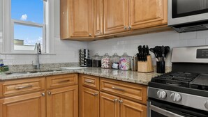 Una cocina con armarios de madera, una estufa de acero inoxidable y un microondas.