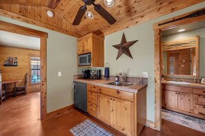 Una cocina con armarios de madera, un microondas y una decoración con forma de estrella en la pared.