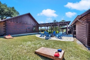 Una cabaña de madera con un patio que incluye asientos exteriores y una pérgola.
