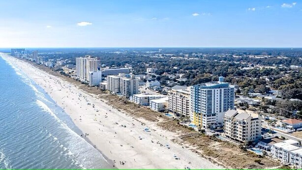 A coastal cityscape with a beach, high-rise buildings, and a clear sky. - North Myrtle Getaway, 2bd 2ba bottom unit in 3unit building 1-block from beach (North Myrtle Beach)