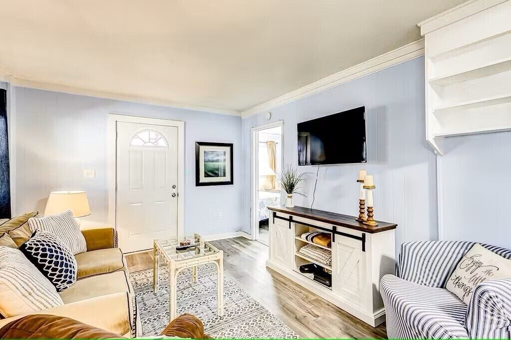 A living room with a sofa, a coffee table, a TV, and a fireplace.