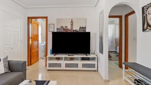 A living room with a flat-screen TV, a sofa, a coffee table, and a bookshelf. - Vacation home Hamber by Interhome (Puerto de Mazarrón)