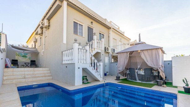 A swimming pool with a white staircase leading to a balcony, a covered outdoor seating area, and a garden with a cactus. - Vacation home Hamber by Interhome (Puerto de Mazarrón)