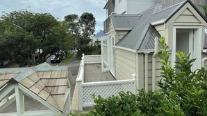 A residential building with a sloped roof, a white fence, and lush greenery in the foreground. - Parnell Self-Contained Cottage

 (Auckland)