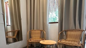A room with two wicker chairs, a round table with a woven base, and a mirror on the wall. - AROEIRA POUSADA TRANCOSO (Porto Seguro)