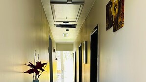 A hallway with a glass table, a vase with plants, and artwork on the walls. - 3 Bedroom cozy villa in Werribee near  Werribee CBD and other amenities (Werribee)