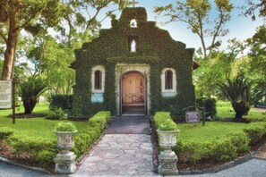A small church with a stone pathway leading to the entrance, surrounded by well-maintained greenery and a clear sky. - Ocean Reef 101 - Ocean Bliss (St Augustine Beach)