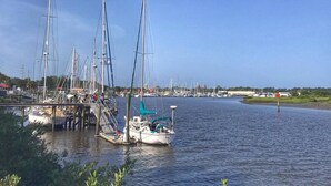A marina with multiple sailboats docked at wooden piers.