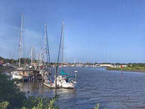 A marina with multiple sailboats docked at wooden piers.