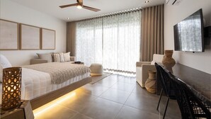Una habitación de hotel moderna con una cama, un escritorio, una silla y un ventilador de techo.