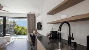 Una cocina moderna con un lavamanos grande, una estufa integrada y un comedor con vistas a la piscina.