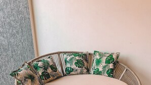 A round outdoor seating area with a cushioned bench and patterned cushions. - Casa Refúgio (Cruz)