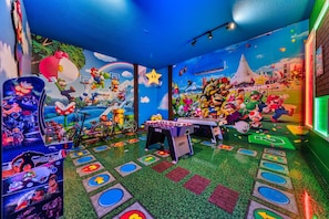 A room with a foosball table, a bicycle, and a Mario-themed mural. - The Luxurious Bear's Den Estate-TB009 (Kissimmee)