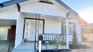 A single-story house with a front porch, a mailbox, and a number 945 sign.