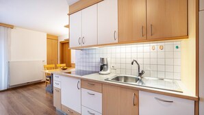 A modern kitchen with wooden cabinets, a stainless steel sink, and a coffee maker. - Apartment 'Linder 20' with Mountain View, Shared Pool and Wi-Fi (Natz)
