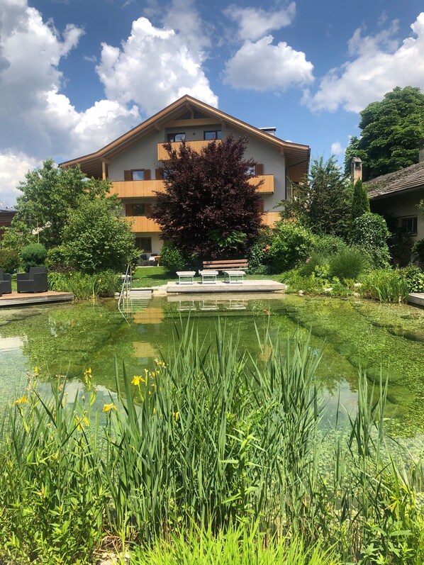 A building with a garden and a pond.