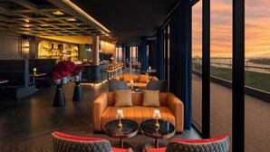 A modern lounge area with sofas, tables, and a bar. - Amari Vientiane Laos (Vientiane)