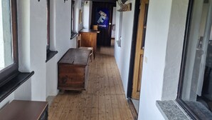 A corridor with wooden flooring, a bench, and a table.