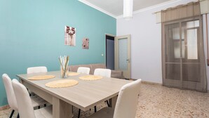 A dining area with a table, chairs, and a door with a frosted glass panel.