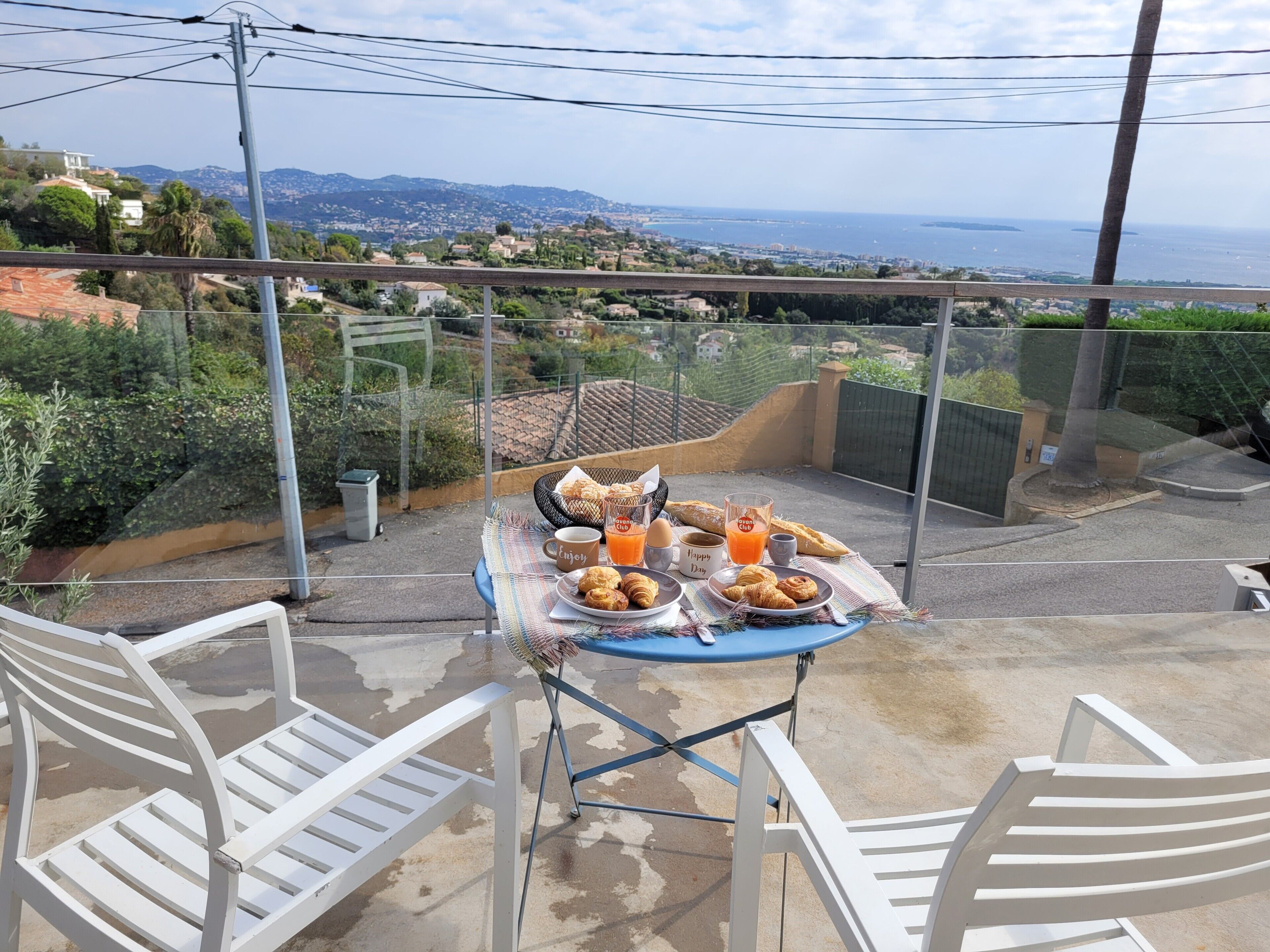 Ein Balkon mit Frühstückstisch und Blick auf eine malerische Küstenstadt.