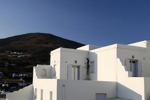 Um edifício branco com teto plano, uma janela pequena e uma porta.