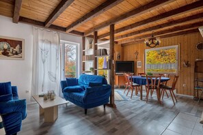Un interior de madera con un sofá, una mesa de comedor y sillas.