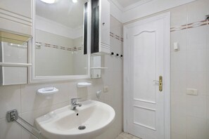 A bathroom with a white sink, a mirror, and a door. - Vacation 'Ceyla' with Sea View, Private Terrace and Wi-Fi (Arona)