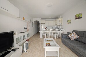 A modern living room with a flat-screen TV, a grey sofa, and a coffee table. - Vacation 'Ceyla' with Sea View, Private Terrace and Wi-Fi (Arona)