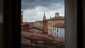 A view through an open doorway of a historic town with buildings, a church, and a bell tower. - Country House 'El Desvan Del Brigante' with Balcony, Wi-Fi and Air Conditioning (Lerma)