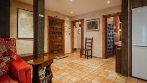 A room with a wooden door labeled 'SALIDA,' a chair, a table, a map on the wall, and a refrigerator. - Country House 'El Desvan Del Brigante' with Balcony, Wi-Fi and Air Conditioning (Lerma)