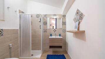Un baño con ducha, lavamanos e inodoro.