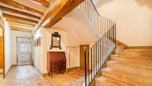 A staircase with stone steps and a metal railing, leading to an upper floor.